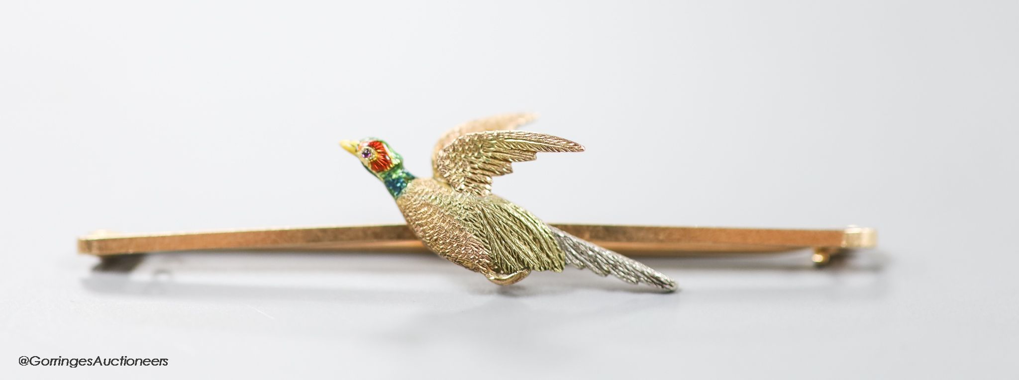 An Edwardian three colour 15ct and two colour enamel 'grouse in flight' bar brooch, 61mm, gross 4.8 grams.